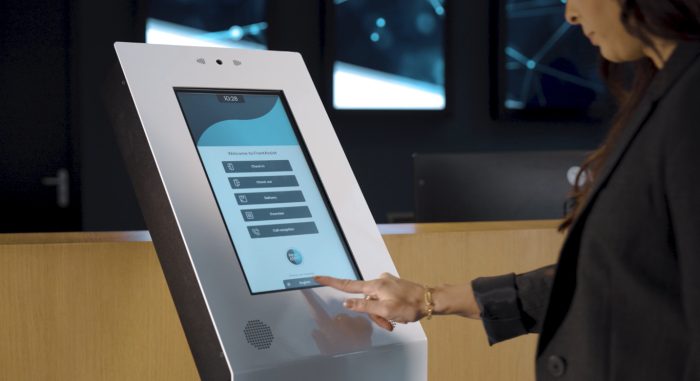 Visitor checking in on an MGtal reception kiosk at a front desk